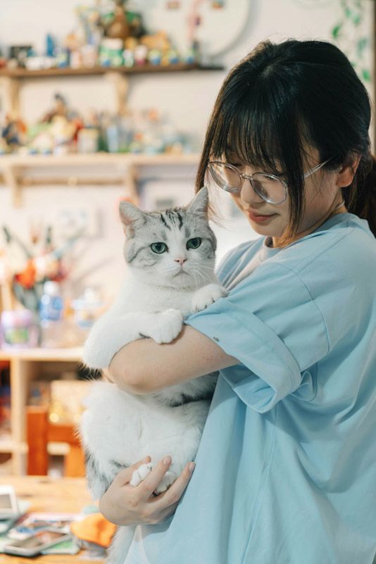 A Female Veterinarian holding a white cat